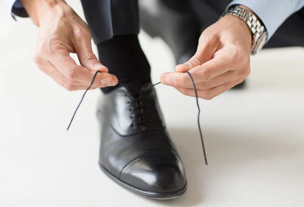 Närbild på man ben och händer knyta skosnören — Stockfoto