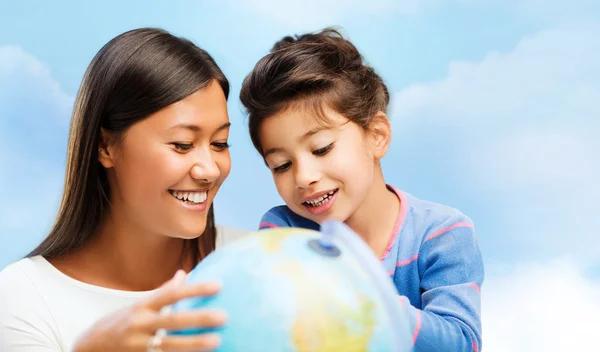 Happy mother and daughter with globe — Stock Photo, Image