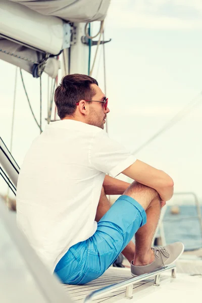 Człowiek siedzi na pokładzie jachtu — Zdjęcie stockowe