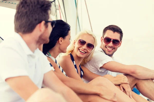 Amigos sonrientes sentados en la cubierta del yate — Foto de Stock