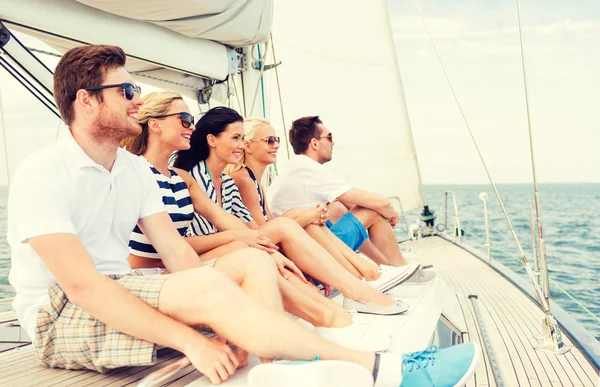 Leende vänner sitter på yacht däck — Stockfoto