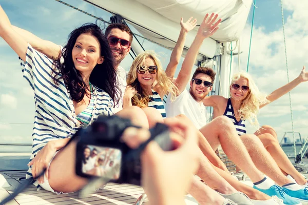 Amigos sonrientes fotografiando en yate — Foto de Stock