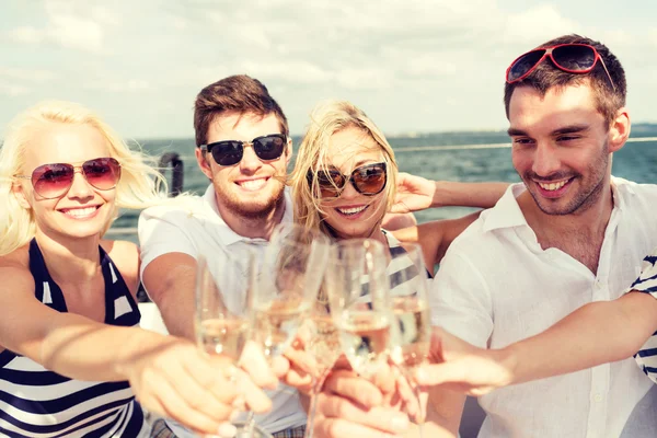 Amigos sorridentes com copos de champanhe no iate — Fotografia de Stock