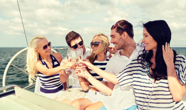 Amigos sonrientes con copas de champán en el yate —  Fotos de Stock