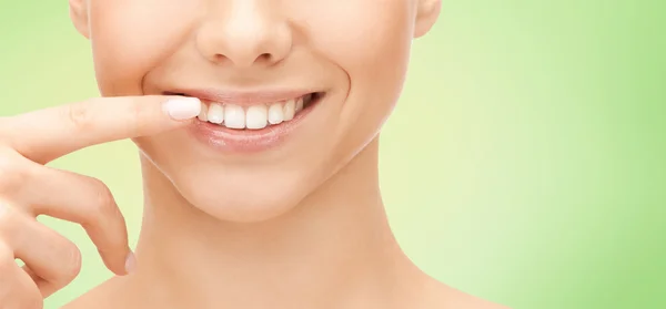 Primer plano de cara de mujer sonriente apuntando a los dientes — Foto de Stock