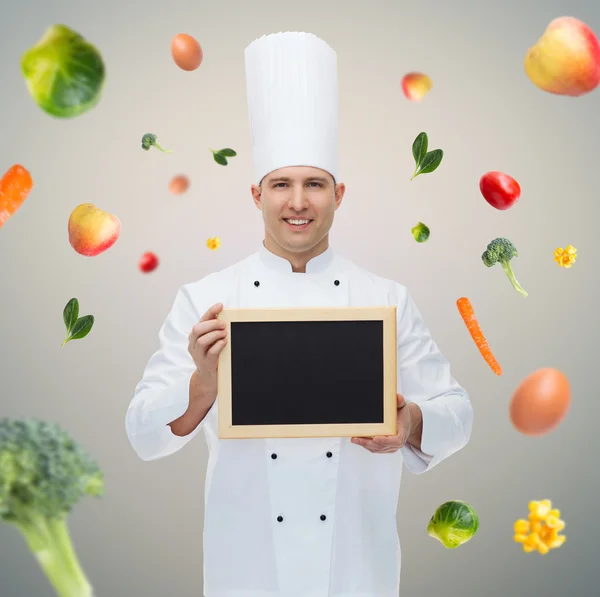 Chef feliz cozinheiro masculino segurando placa de menu em branco — Fotografia de Stock