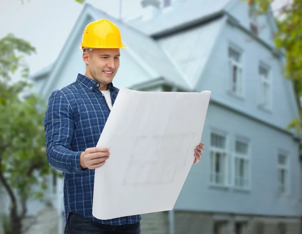 Constructor sonriente con plano sobre la casa —  Fotos de Stock