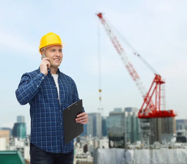 Sorridente construtor masculino no capacete com prancheta — Fotografia de Stock