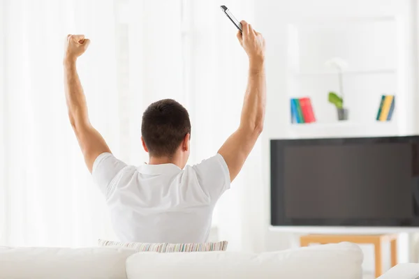 Homem assistindo tv e equipe de apoio em casa — Fotografia de Stock