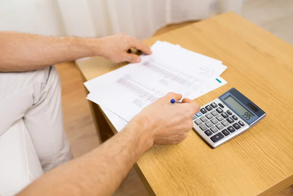 Close up de homem com papéis e calculadora em casa — Fotografia de Stock