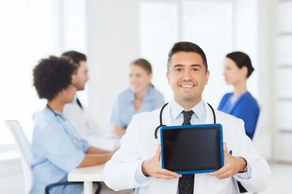 Zufriedener Arzt mit Tablet-PC über Team in Klinik — Stockfoto