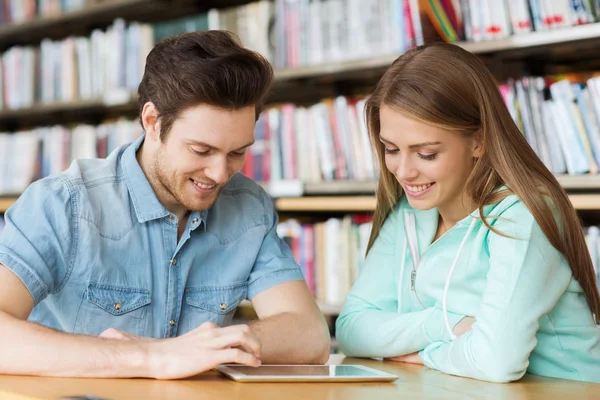Studenti felici con tablet pc in biblioteca — Foto Stock