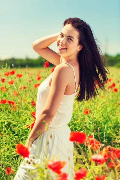 Sonriente joven mujer en amapola campo — Foto de Stock
