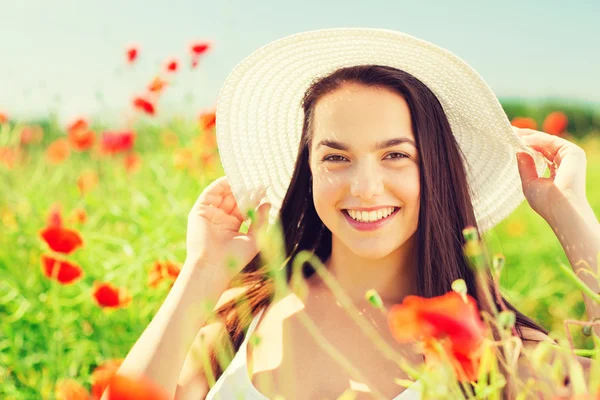 Giovane donna sorridente in cappello di paglia sul campo di papavero — Foto Stock