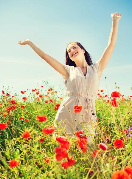 Smiling young woman on poppy field — Stock Photo, Image