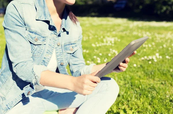 Close up of girl with tablet pc sitting on grass — Stock Photo, Image