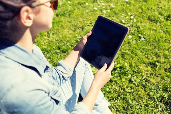 女孩坐在草地上的 tablet pc 的特写 — 图库照片