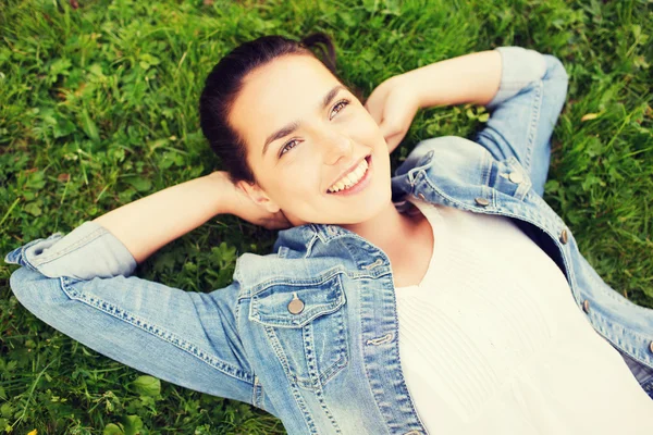 Souriant jeune fille couchée sur l'herbe — Photo