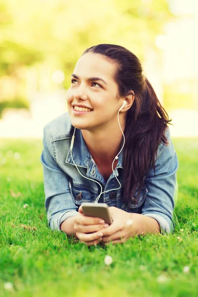 Lachende jong meisje met smartphone en koptelefoon — Stockfoto