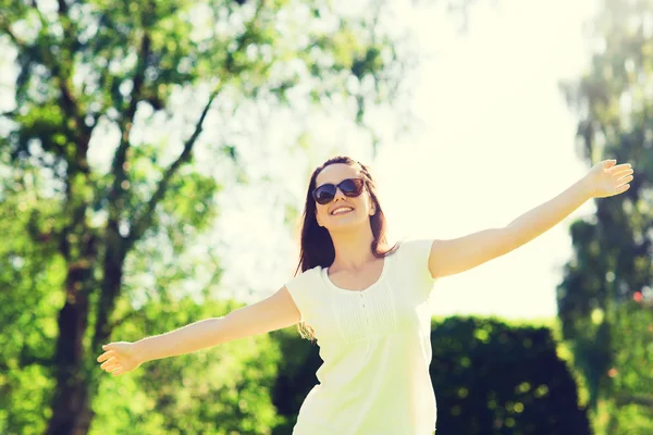 Lachende jonge vrouw met zonnebril in park — Stockfoto