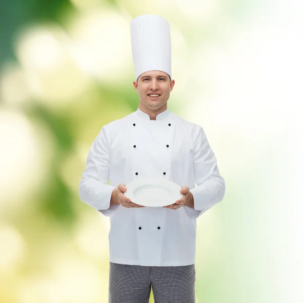 Cocinero macho feliz mostrando plato vacío —  Fotos de Stock