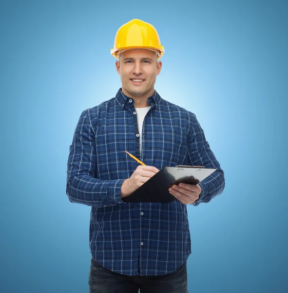 Sorridente construtor masculino no capacete com prancheta — Fotografia de Stock