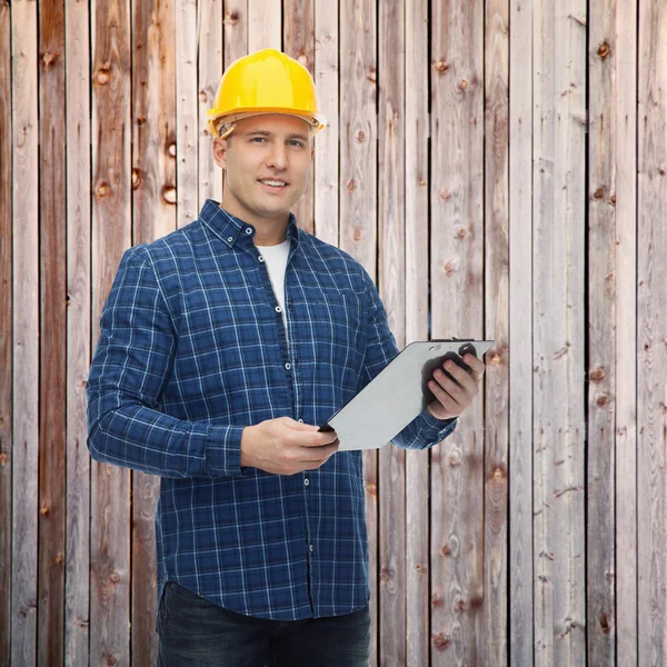 Uśmiechnięty mężczyzna konstruktora w hełm ze schowka — Zdjęcie stockowe