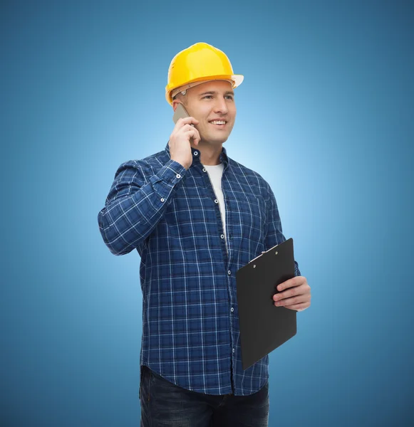 Sorridente construtor masculino no capacete com prancheta — Fotografia de Stock