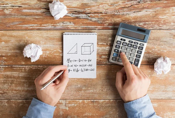 Perto de mãos com tarefa de resolução de calculadora — Fotografia de Stock