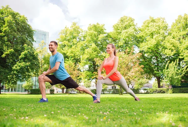 Sonriente pareja estirándose al aire libre — Foto de Stock