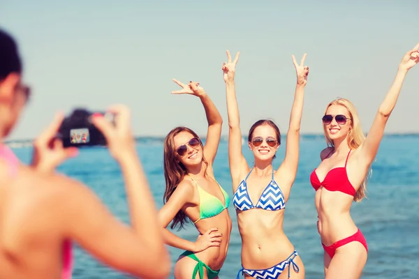 Groupe de femmes souriantes photographiant sur la plage Images De Stock Libres De Droits