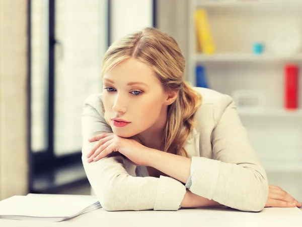 Femme ennuyée et fatiguée derrière la table — Photo