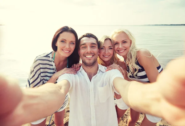 Glada vänner på stranden och ta selfie — Stockfoto