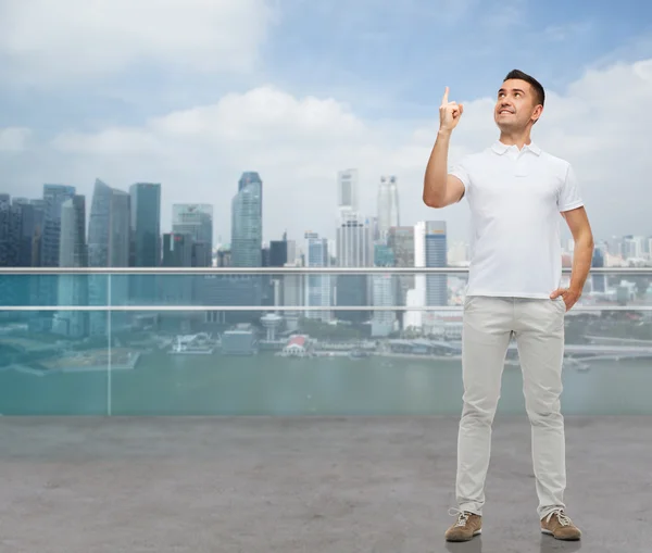 Uomo sorridente puntando il dito verso l'alto — Foto Stock