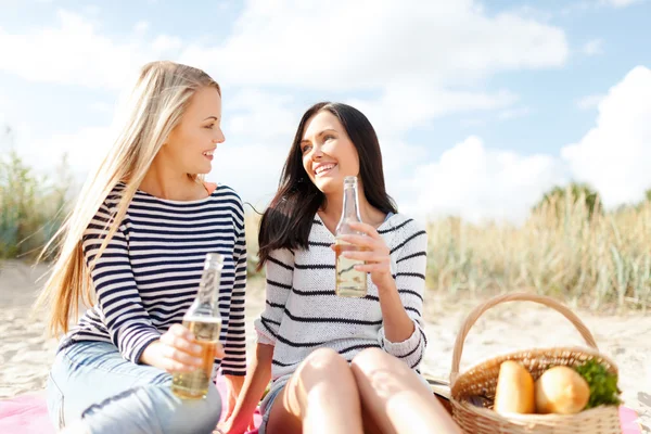 Happy young women drinking beer on beach — Stock Photo, Image