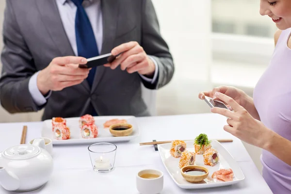 Close up of couple with smartphones at restaurant — Stock Photo, Image