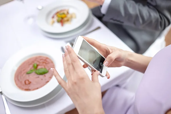 Закрыть пару со смартфонами в ресторане — стоковое фото