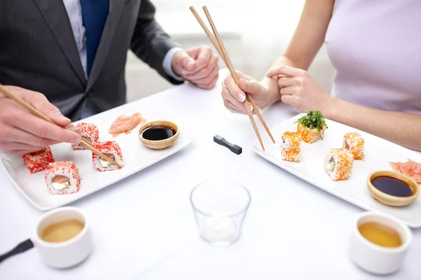 Close up de casal comer sushi no restaurante — Fotografia de Stock