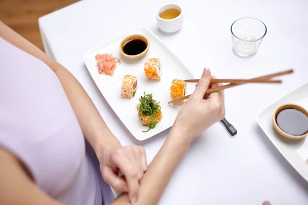 Zamknij się z kobieta jedzenie sushi w restauracji — Zdjęcie stockowe