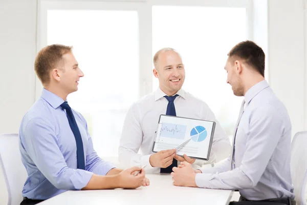 Hombres de negocios sonrientes con papeles en la oficina — Foto de Stock