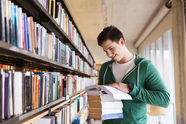 Щасливий студент або чоловік з книгою в бібліотеці — стокове фото