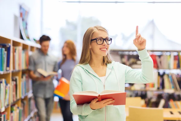 Happy student girl or woman with book in library — Stock Photo, Image