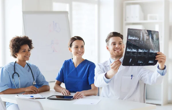 Группа счастливых врачей обсуждают рентгеновское изображение — стоковое фото