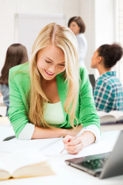 Student girl writing in notebook at school Royalty Free Stock Photos