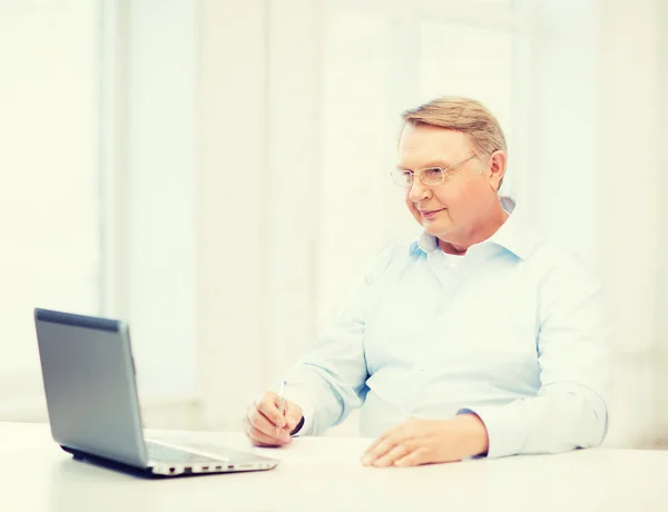 Oude man in brillen invullen van een formulier thuis — Stockfoto