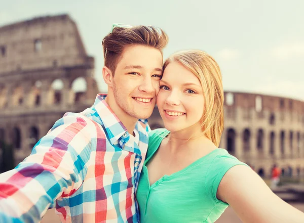 Sorridente coppia prendere selfie oltre coliseum — Foto Stock