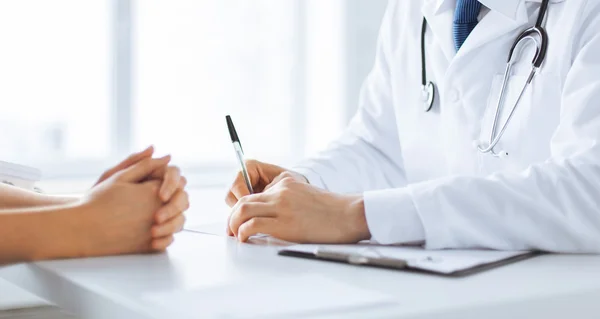 Paciente e médico tomando notas — Fotografia de Stock