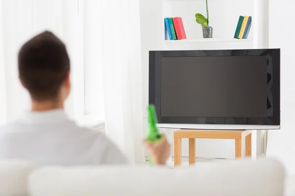 TV izlerken, evde bira içme adam — Stok fotoğraf