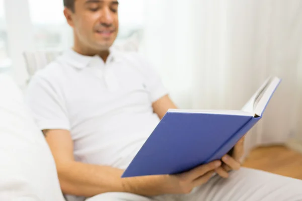 Primer plano del hombre feliz leyendo libro en casa — Foto de Stock