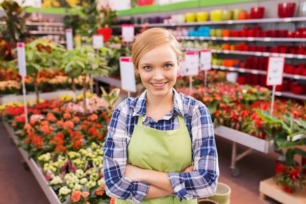 Happy woman with flowers in greenhouse — Stock Photo, Image